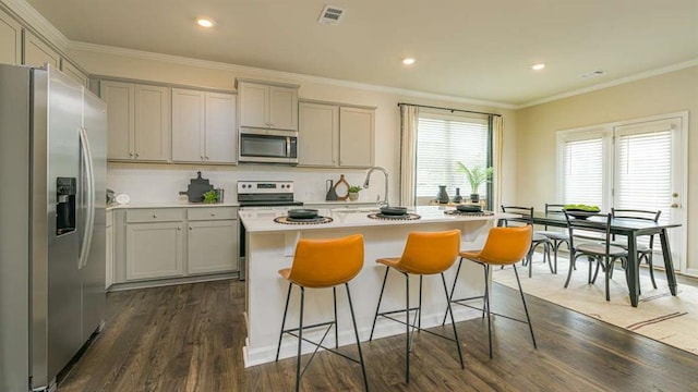 kitchen with ornamental molding, appliances with stainless steel finishes, dark wood-type flooring, and backsplash