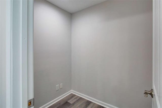 spare room with dark wood-type flooring and baseboards