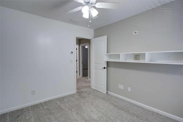 spare room featuring baseboards, ceiling fan, visible vents, and light colored carpet