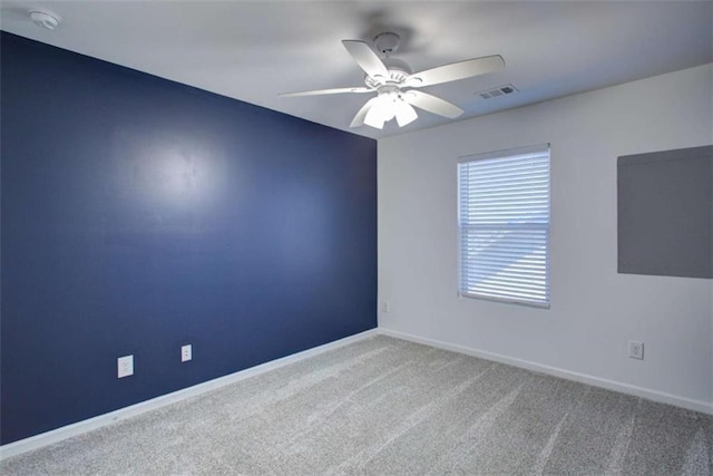 carpeted empty room with a ceiling fan, visible vents, and baseboards