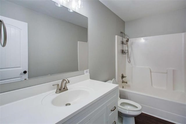 bathroom with toilet, bathtub / shower combination, wood finished floors, and vanity