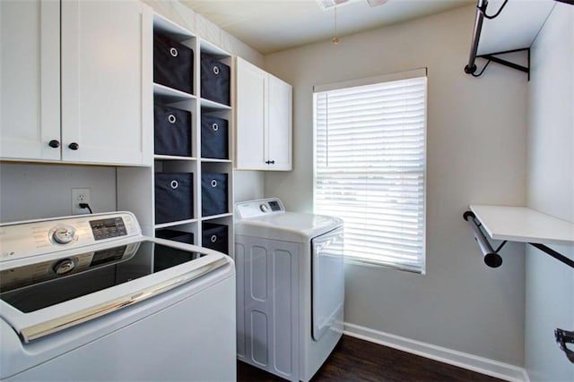 laundry room featuring dark wood-style floors, separate washer and dryer, cabinet space, and baseboards