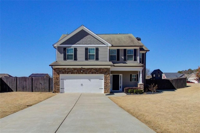 craftsman-style house with a garage, fence, driveway, stone siding, and a front lawn