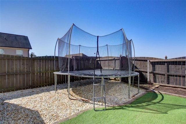 view of yard featuring a fenced backyard and a trampoline