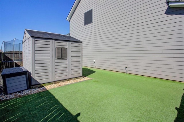 view of yard with fence, a storage unit, and an outbuilding