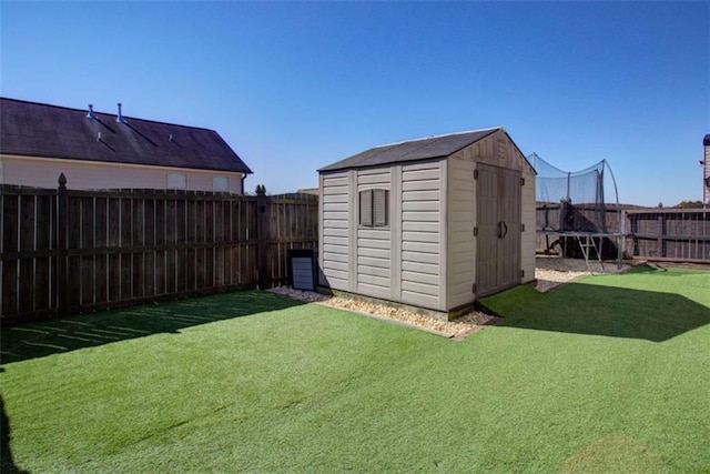 view of shed featuring a fenced backyard and a trampoline