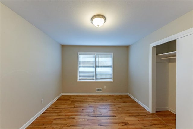 unfurnished bedroom with a closet and light wood-type flooring