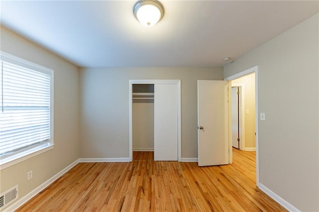 unfurnished bedroom featuring light hardwood / wood-style floors and a closet