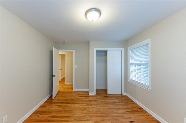 unfurnished bedroom with light hardwood / wood-style flooring and a closet