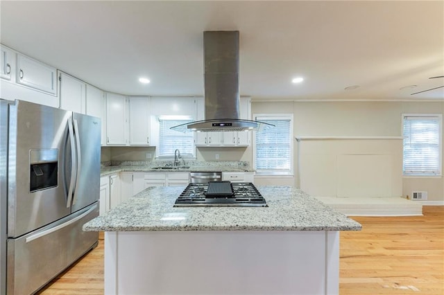 kitchen featuring island exhaust hood, white cabinets, stainless steel appliances, and sink