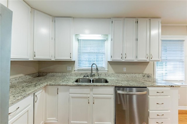 kitchen featuring white cabinets, light stone countertops, stainless steel dishwasher, light wood-type flooring, and sink