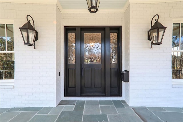 property entrance featuring brick siding