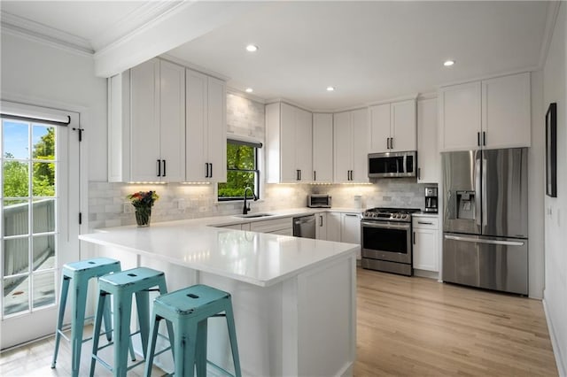 kitchen with ornamental molding, decorative backsplash, appliances with stainless steel finishes, and light countertops