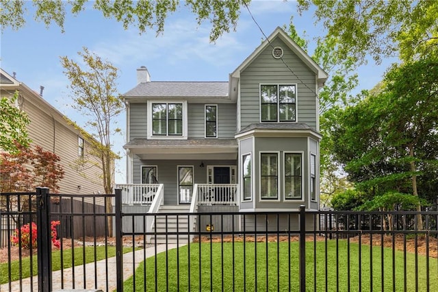 view of front of house with a porch, a chimney, a front yard, and a fenced front yard