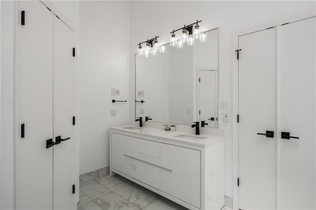 bathroom with marble finish floor, a sink, and double vanity