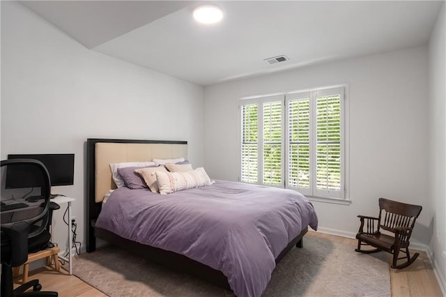 bedroom with light wood-type flooring, baseboards, and visible vents