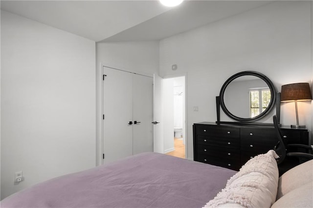 bedroom with vaulted ceiling and a closet