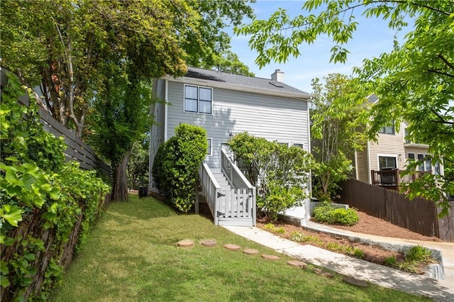 view of yard with fence and stairs