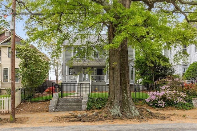view of front facade featuring covered porch and a fenced front yard
