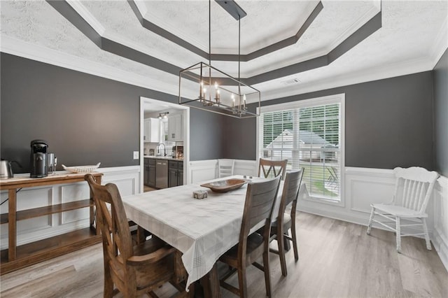 219 Summit Chase Dr, Jefferson, GA 30549 - dining room with a raised ceiling, light wood finished floors, a chandelier, a wainscoted wall, and a decorative wall