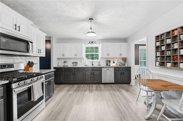 219 Summit Chase Dr, Jefferson, GA 30549 - kitchen with stainless steel appliances, white cabinets, gray cabinets, light wood-type flooring, and tasteful backsplash