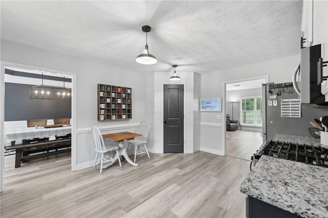 219 Summit Chase Dr, Jefferson, GA 30549 - kitchen featuring light wood-type flooring, white cabinets, decorative light fixtures, gas stove, and a textured ceiling