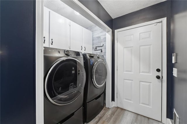 219 Summit Chase Dr, Jefferson, GA 30549 - laundry room featuring cabinet space, separate washer and dryer, light wood finished floors, and a textured ceiling