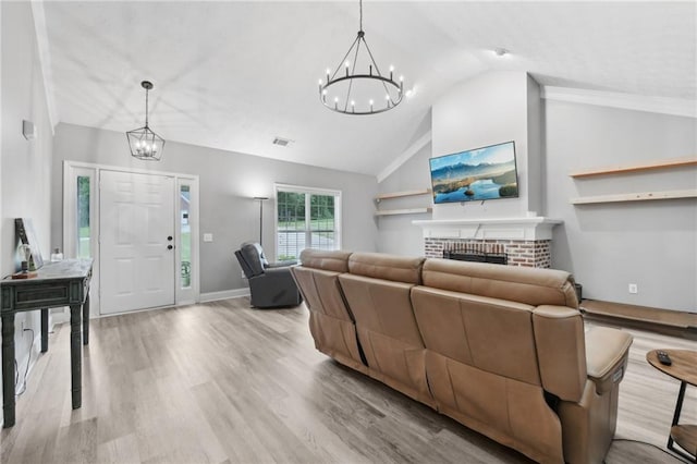 219 Summit Chase Dr, Jefferson, GA 30549 - living area featuring a chandelier, vaulted ceiling, a brick fireplace, wood finished floors, and baseboards