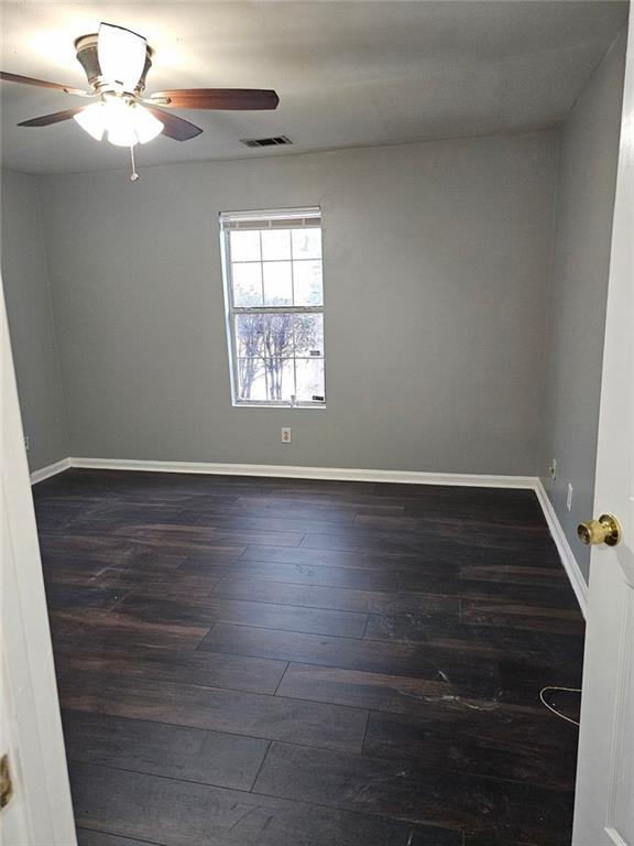 empty room with ceiling fan and dark hardwood / wood-style floors