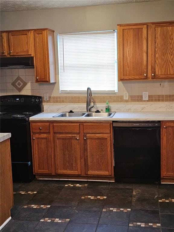 kitchen with tasteful backsplash, sink, black appliances, and a textured ceiling