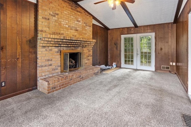 1513 Dupree Rd, Woodstock, GA 30189 - unfurnished living room with ceiling fan, wooden walls, carpet, a brick fireplace, and french doors