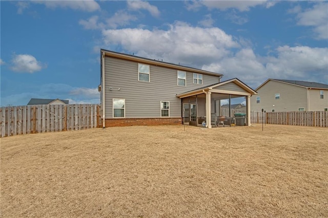 rear view of house with a lawn and a sunroom