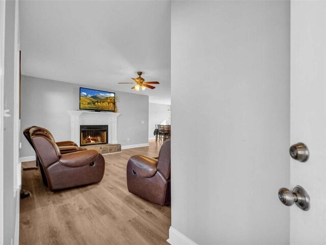 living room with vaulted ceiling, ceiling fan, and light hardwood / wood-style floors