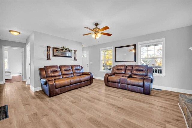 living room featuring light hardwood / wood-style flooring and ceiling fan