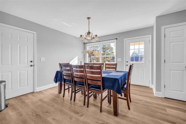 dining space featuring a notable chandelier and light hardwood / wood-style floors