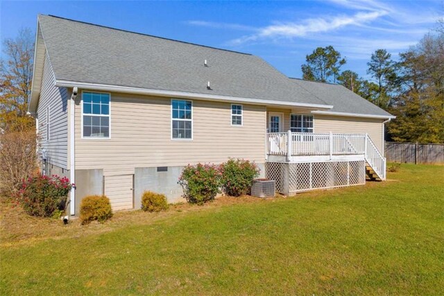 rear view of property with a deck and a lawn