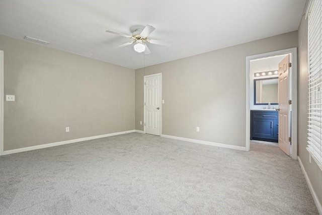 unfurnished bedroom featuring connected bathroom, ceiling fan, sink, and light carpet