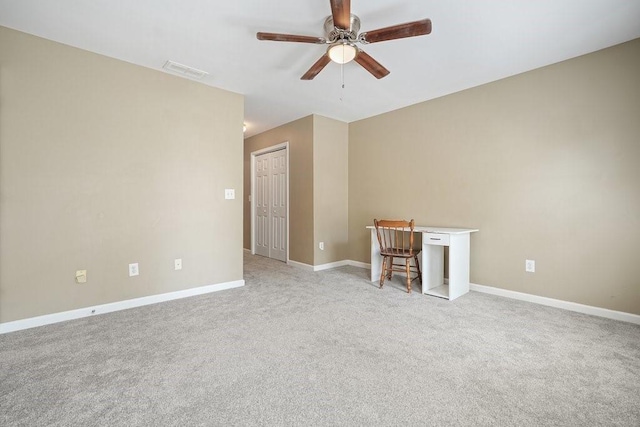 carpeted spare room featuring ceiling fan