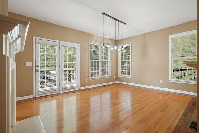 unfurnished dining area with light hardwood / wood-style flooring and an inviting chandelier