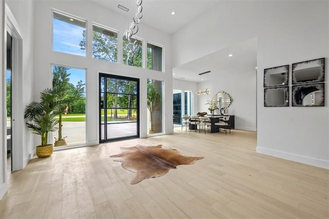 foyer entrance featuring a wealth of natural light, light hardwood / wood-style flooring, and a high ceiling