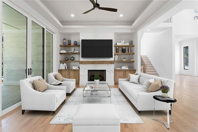 living room with a raised ceiling, light hardwood / wood-style flooring, and plenty of natural light