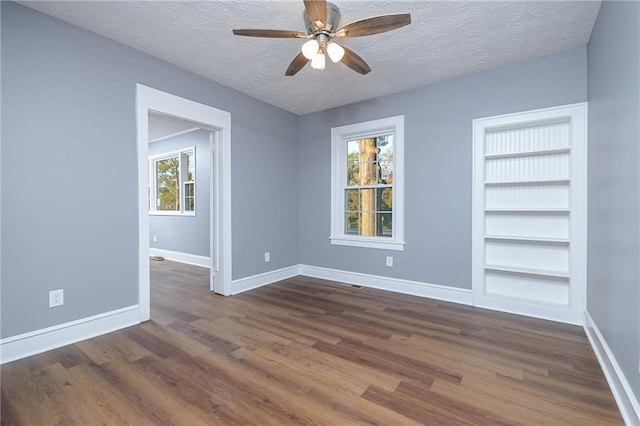 spare room with ceiling fan, dark hardwood / wood-style flooring, and a textured ceiling