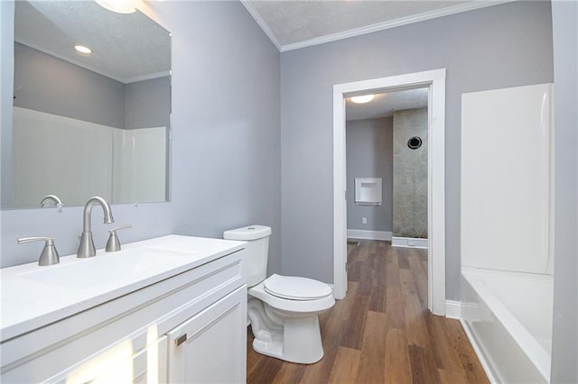 full bathroom with wood-type flooring, ornamental molding, vanity, toilet, and a textured ceiling