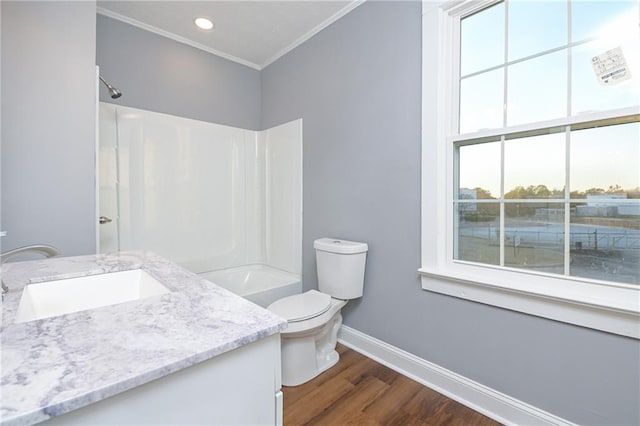 full bathroom featuring shower / bathing tub combination, wood-type flooring, vanity, ornamental molding, and toilet