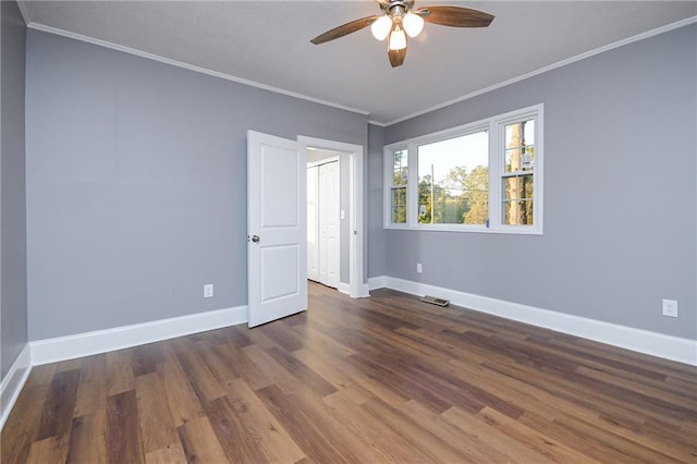 empty room with ceiling fan, ornamental molding, and dark hardwood / wood-style floors