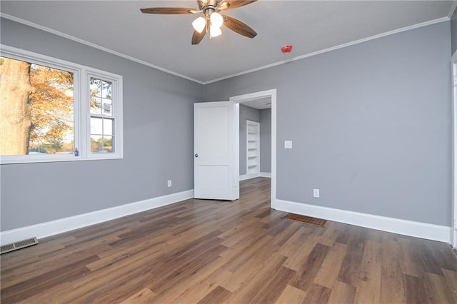 spare room with crown molding, ceiling fan, and dark wood-type flooring