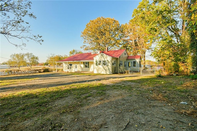 rear view of house with covered porch and a lawn