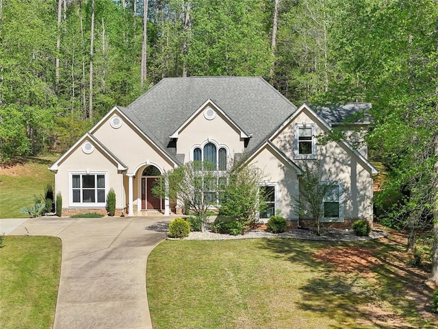 3070 Glad Dale Dr SE, Conyers, GA 30094 - view of front of home featuring roof with shingles, stucco siding, a front lawn, and driveway