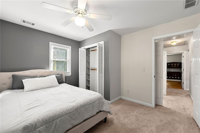 carpeted bedroom with ceiling fan and a closet