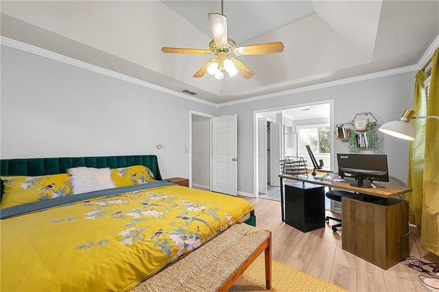 bedroom featuring a raised ceiling, crown molding, and light hardwood / wood-style floors